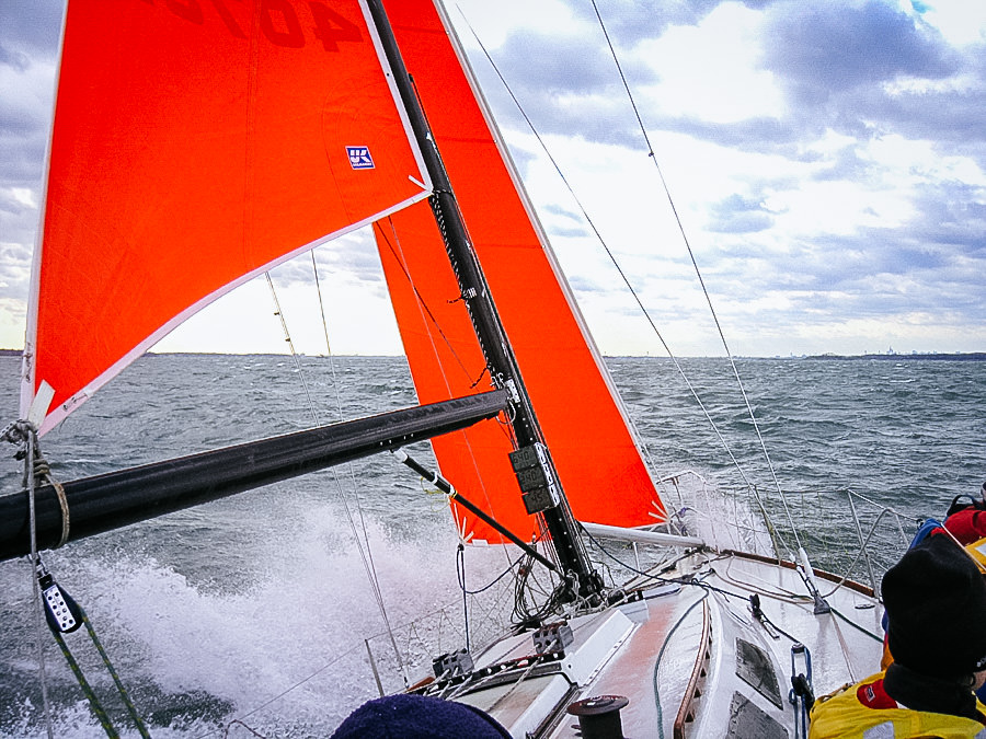 PHOTO 2: Here the trysail is clew is secured to the boom with a reef line and then stropped to the boom with a separate line. With the sail attached to the boom, it can be trimmed with the mainsheet. Sailing TRIPLE LINDY in 30 knots of wind the day …