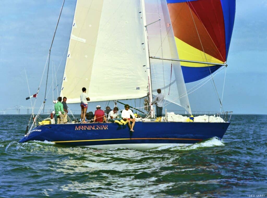 Butch Ulmer onboard MORNINGSTAR, finishing the 1984 St. Pete to Boca Grande and Return race. The Sunshine Skyway is visible in the background. This was the first MORNINGSTAR, a 46-foot IOR racer built by German Frers for John Ambrose. Photo by Larry Moran.