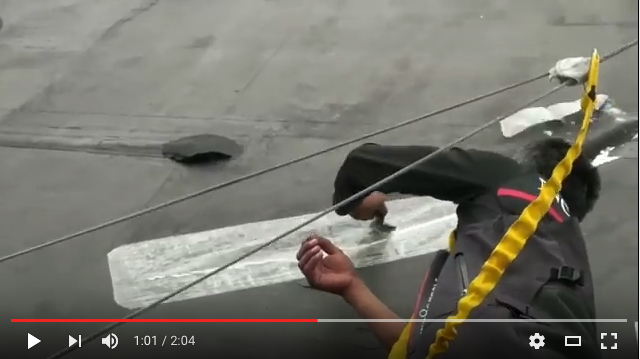 A Volvo 70 mainsail being patched with Dr. Sails while underway.